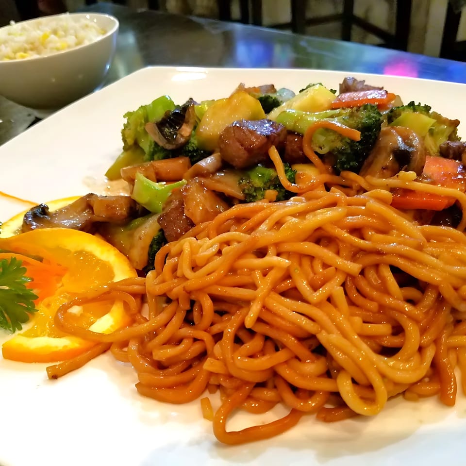 Corner Sushi's Japanese stir-fry with noodles, beef, broccoli, mushrooms, and orange slices.